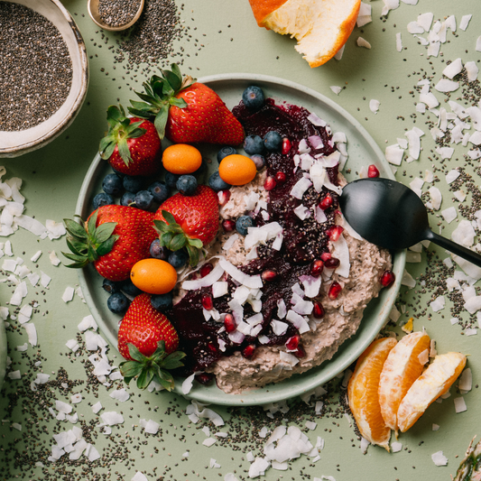 Fruit and dessert bowl with a spoon on a green surface